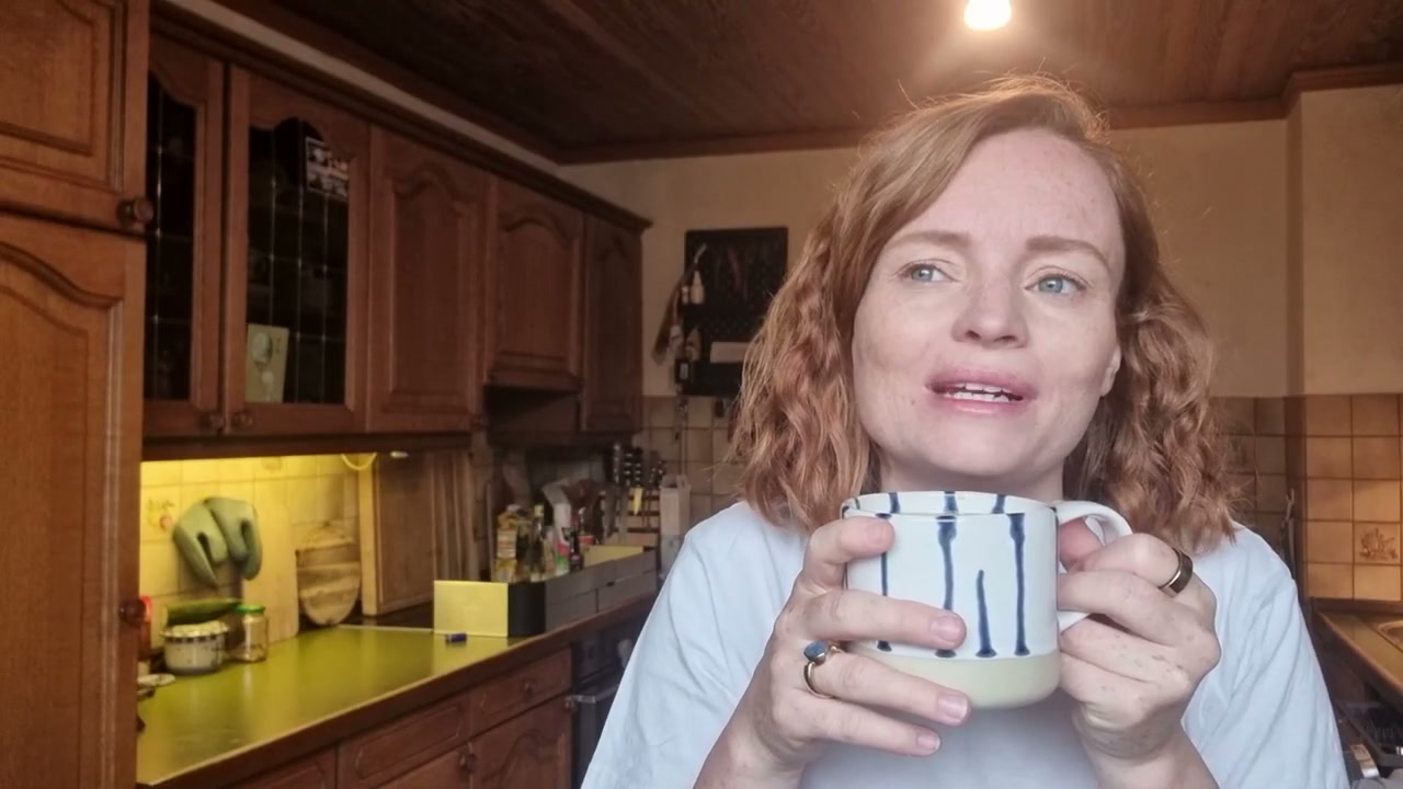 Lisi trinkt morgens Kaffee aus einer gestreiften Tasse in der Küche